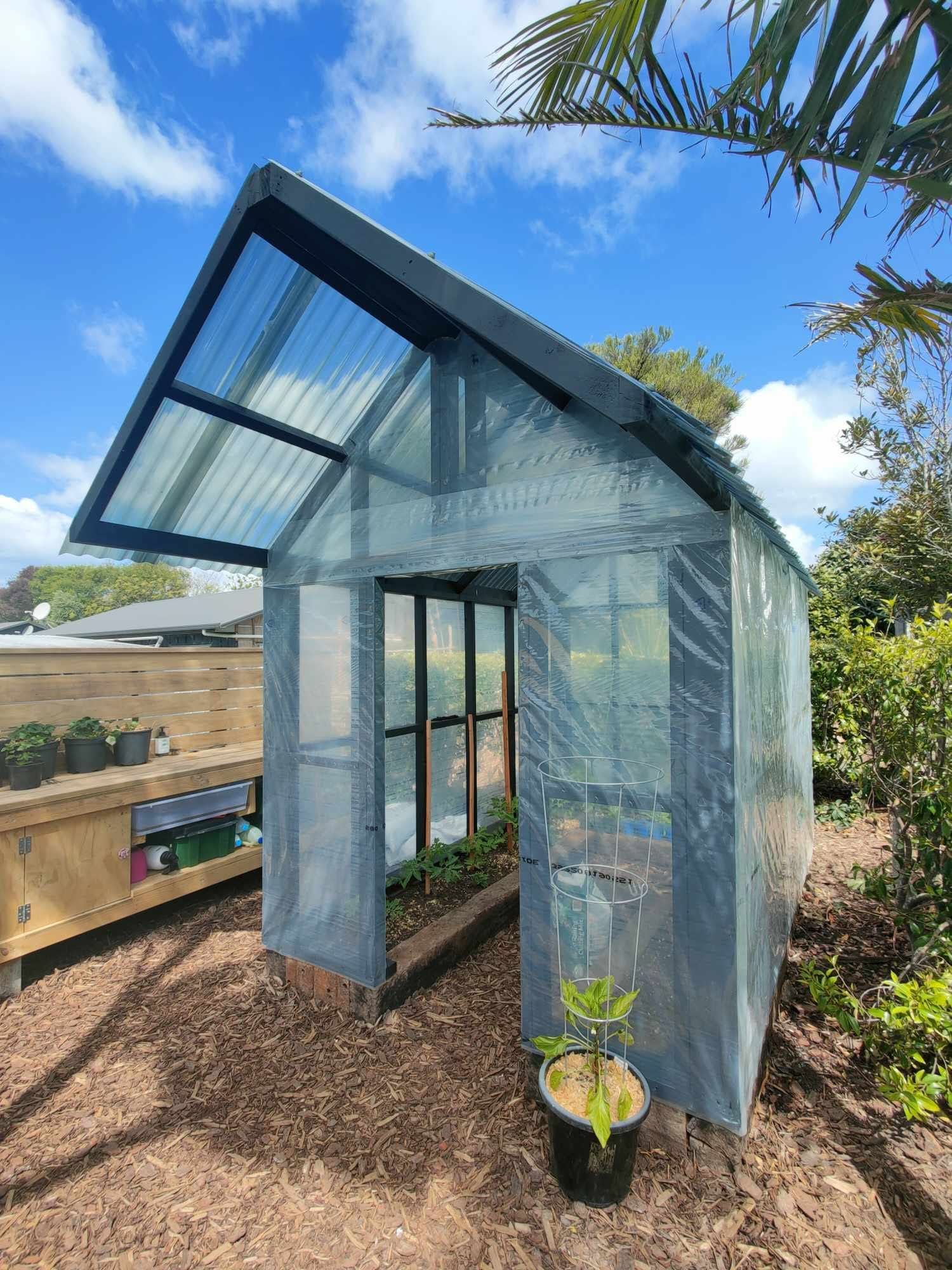 Making the most of the available space with a custom-built polyhouse and raised vegetable boxes crafted from reclaimed railway sleepers, lined with polythene to provide a food-safe growing environment. - After