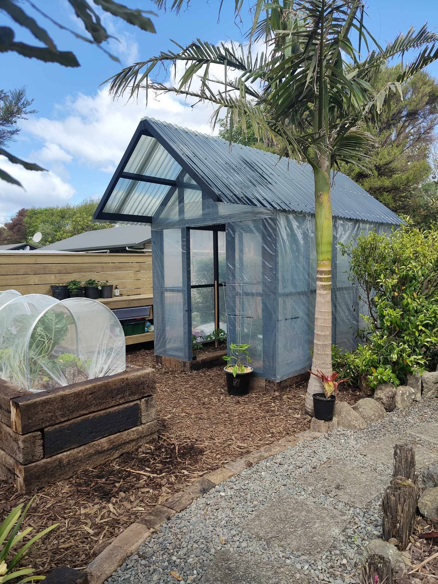Making the most of the available space with a custom-built polyhouse and raised vegetable boxes crafted from reclaimed railway sleepers, lined with polythene to provide a food-safe growing environment. - After