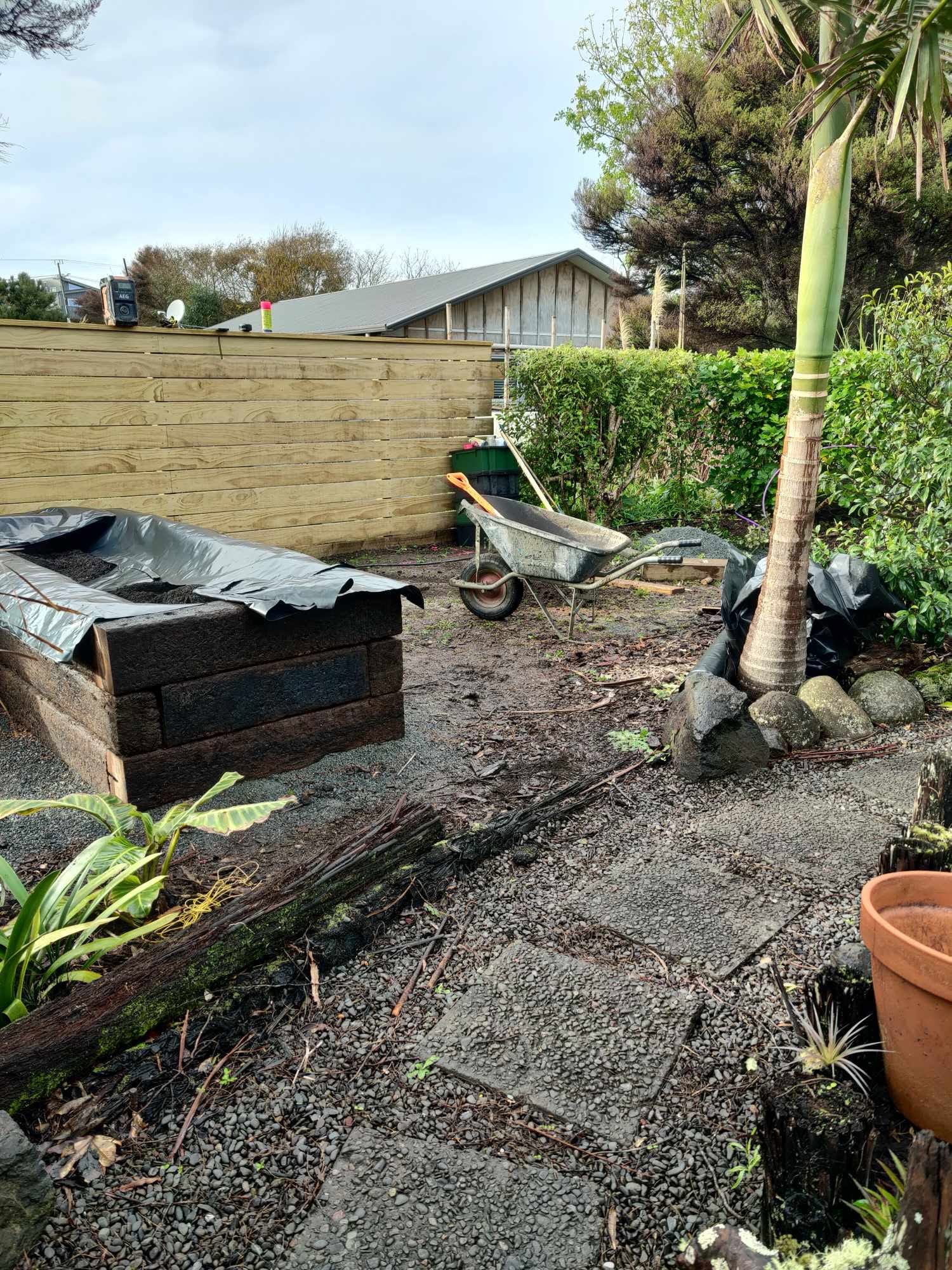 Making the most of the available space with a custom-built polyhouse and raised vegetable boxes crafted from reclaimed railway sleepers, lined with polythene to provide a food-safe growing environment. - Before
